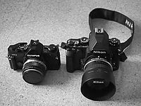 Srovnání rozměrů s profesionální manuální filmovou SLR Olympus OM-2SP (Nikon zrovna nebyl po ruce).