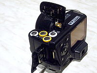 Umístění baterií a karet (xD, SD)